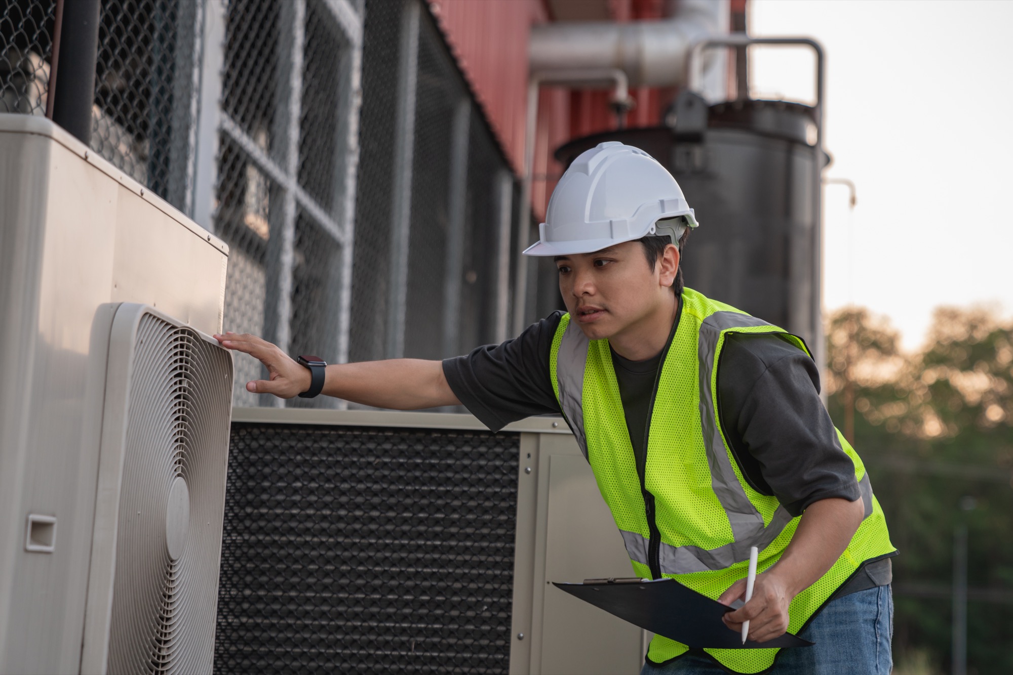 Facilities technician inspecting HVAC equipment at a building